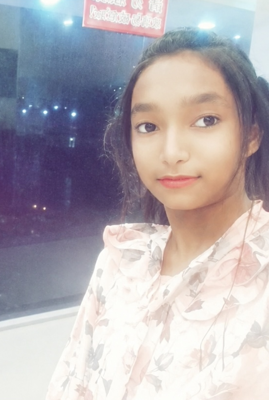 Young Tanya in a soft pink floral outfit with city lights behind her