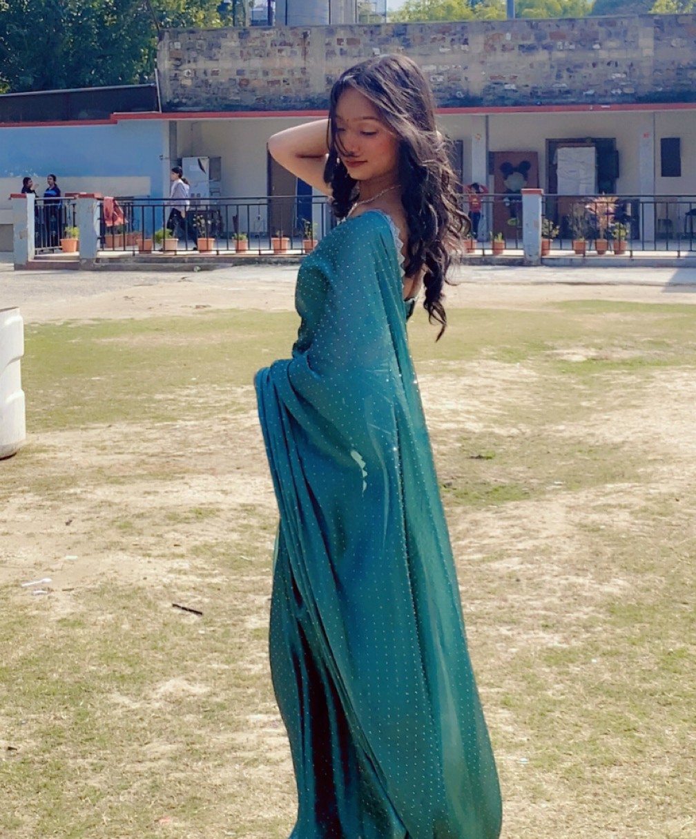 Tanya in a teal saree outdoors